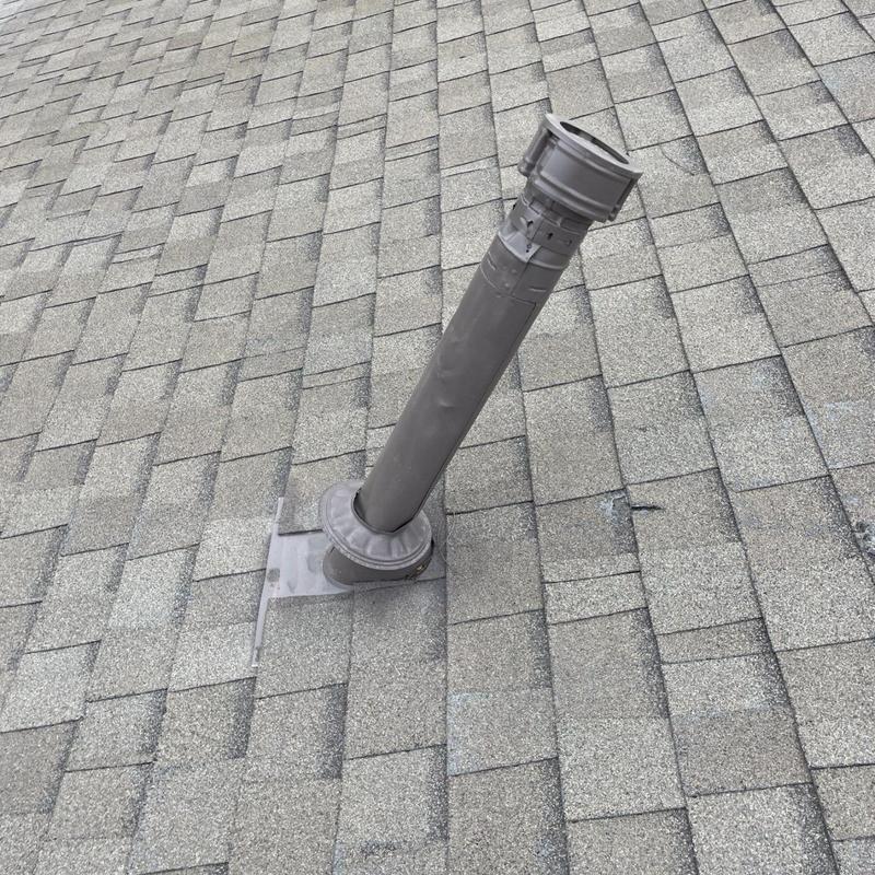 Plumbing vent pipe with new sealed flashing on shingle roof