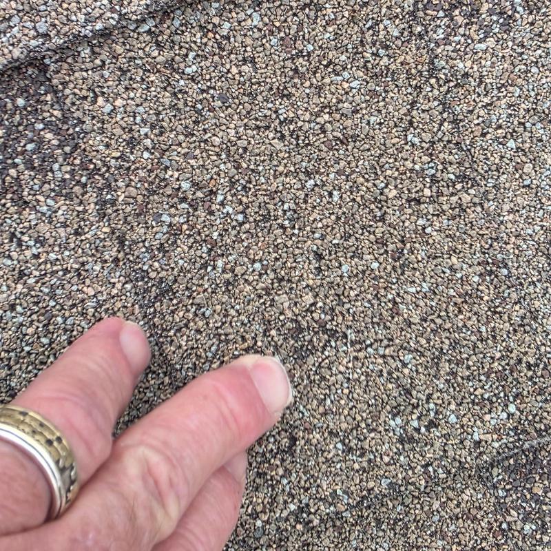 Asphalt roof shingles showing hail damage granules