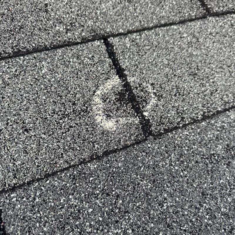 Roof shingle hail damage marked for inspection Roof shingle hail damage marked for inspection