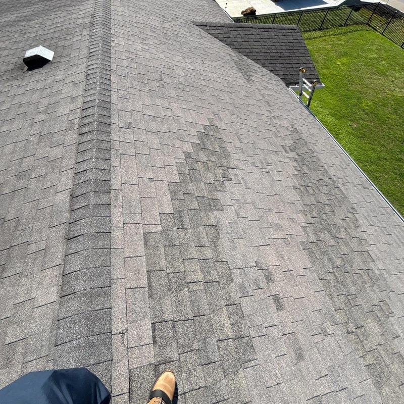 Asphalt shingles with hail damage on roof ridge