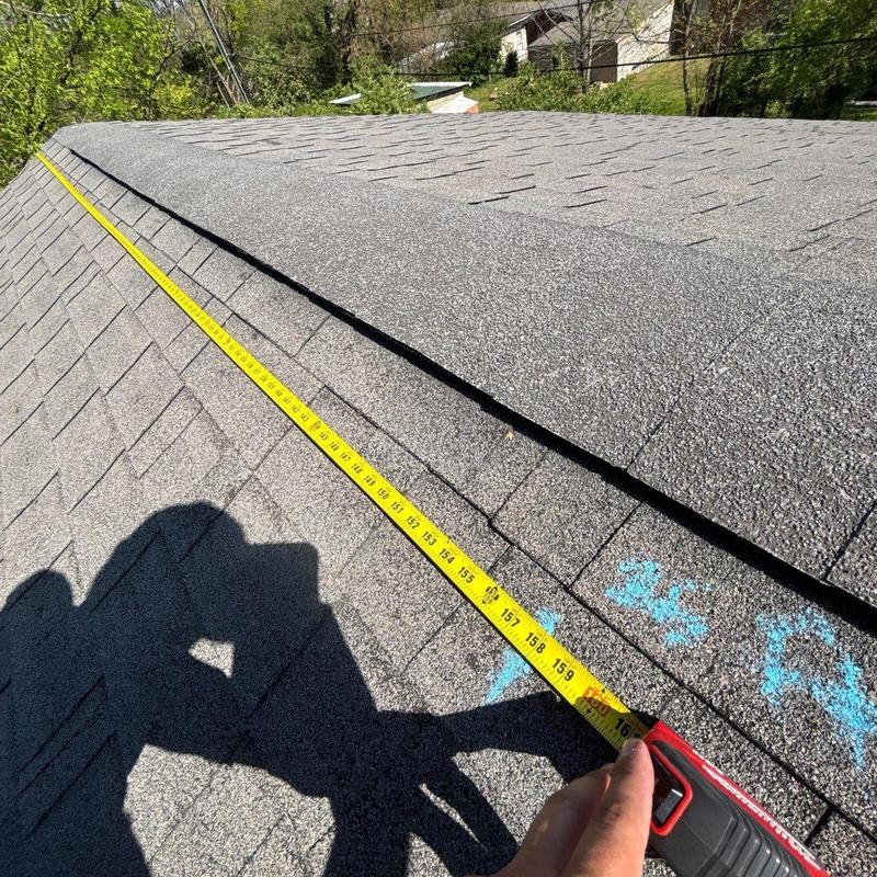 Asphalt shingle roof with tape measure and chalk marks
