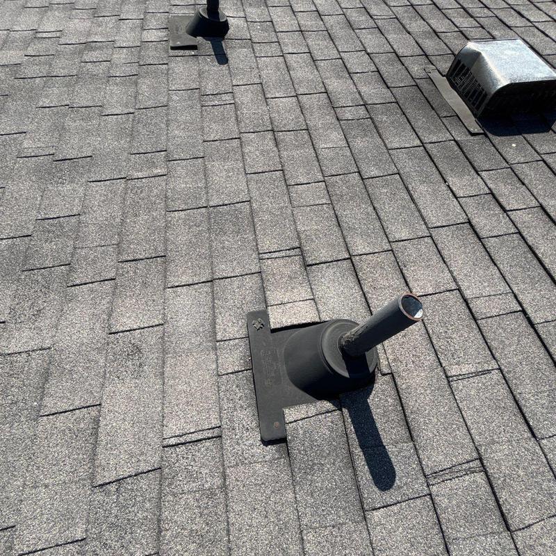 Asphalt shingle roof with vent pipe and flashing seals