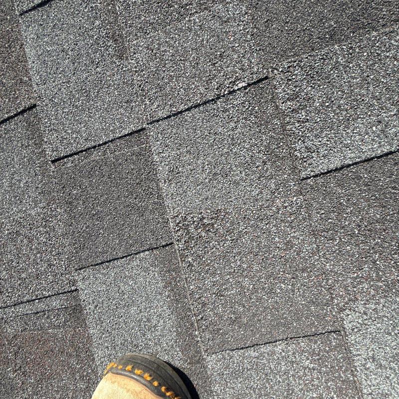 Asphalt shingles showing hail damage on roof surface