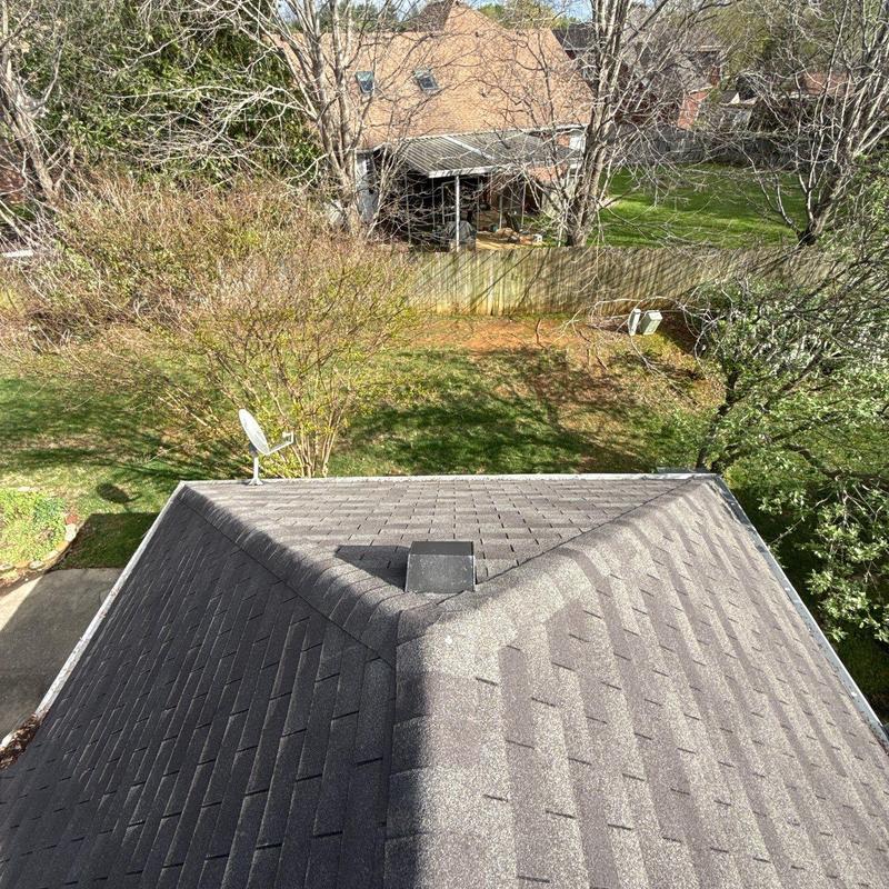 Asphalt shingle roof ridge with ventilation vent and satellite dish