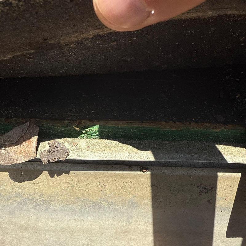 Shingle roof edge with hail damage and debris