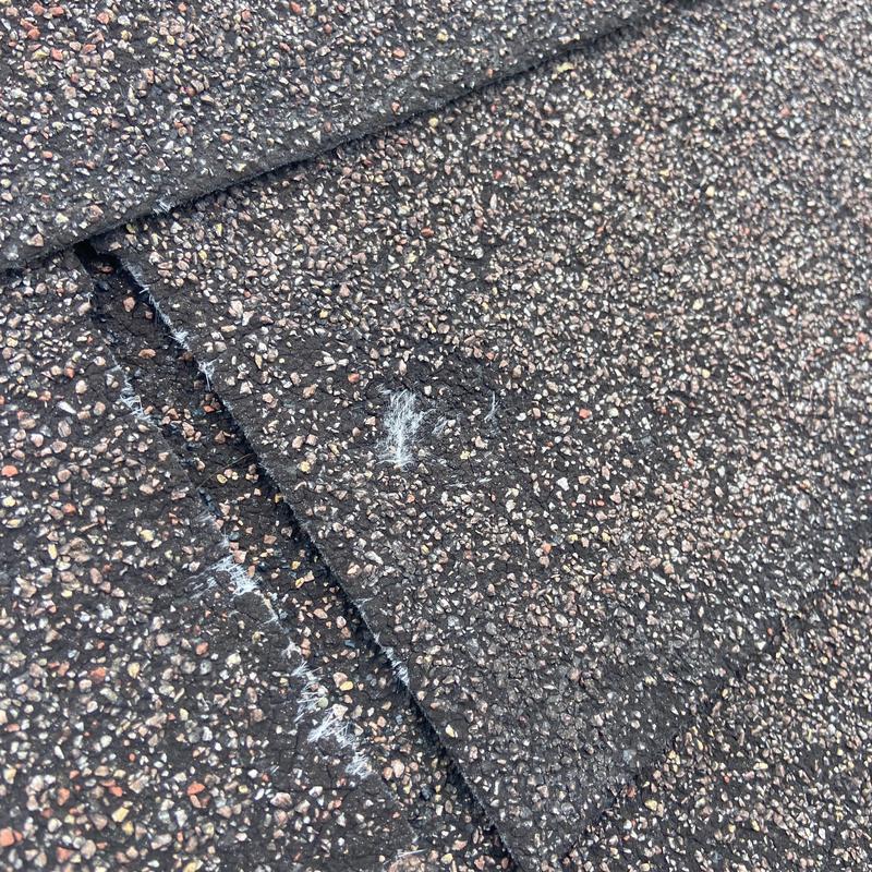 Asphalt shingles with visible hail damage spots