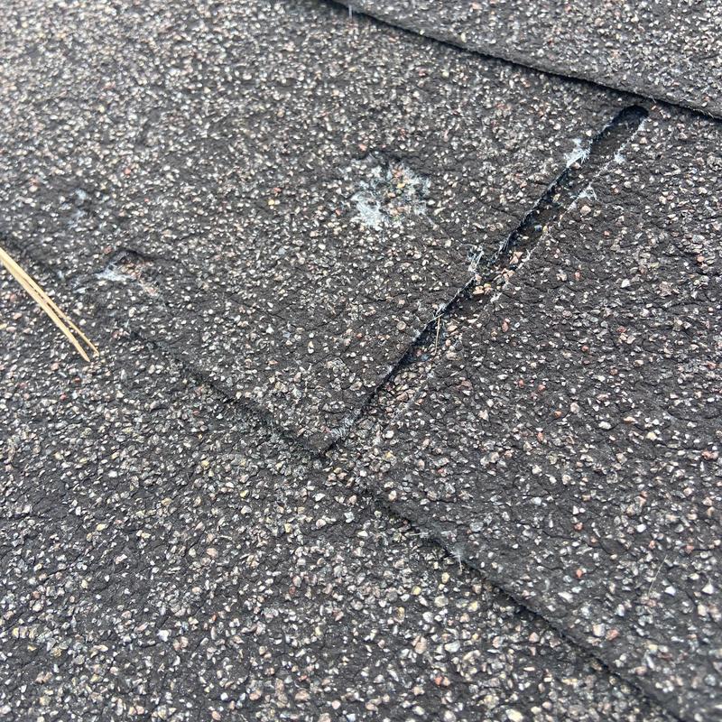 Asphalt shingles with minor storm damage close-up