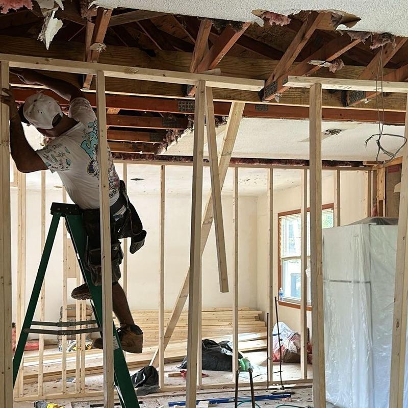 Ceiling joist framing installation with worker on ladder Ceiling joist framing installation with worker on ladder