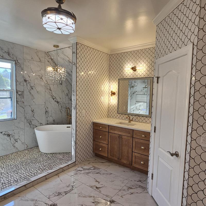 Freestanding bathtub and marble tile bathroom remodel