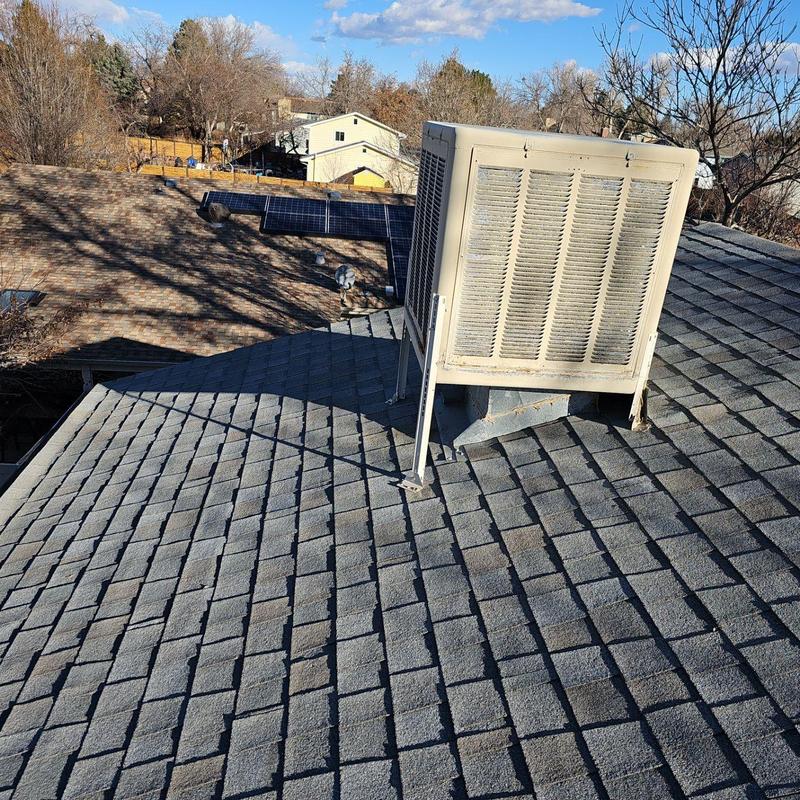 Evaporative cooler on shingle roof with solar panels Evaporative cooler on shingle roof with solar panels