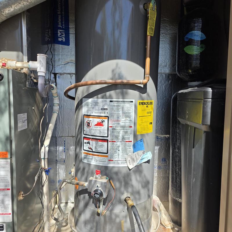 Water heater with new anode rod installation in utility room