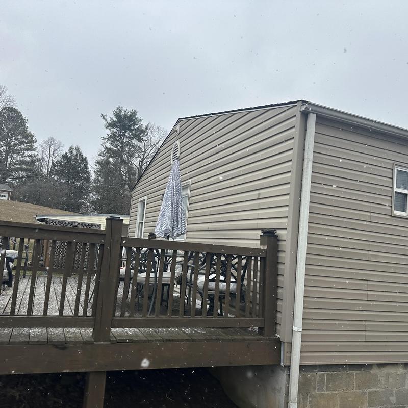 Vinyl siding exterior wall with deck railing in snow
