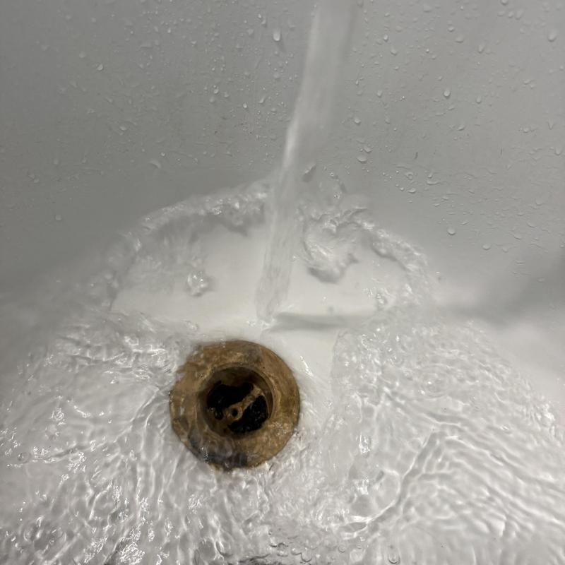 Bathtub drain clearing with running water flow restoration
