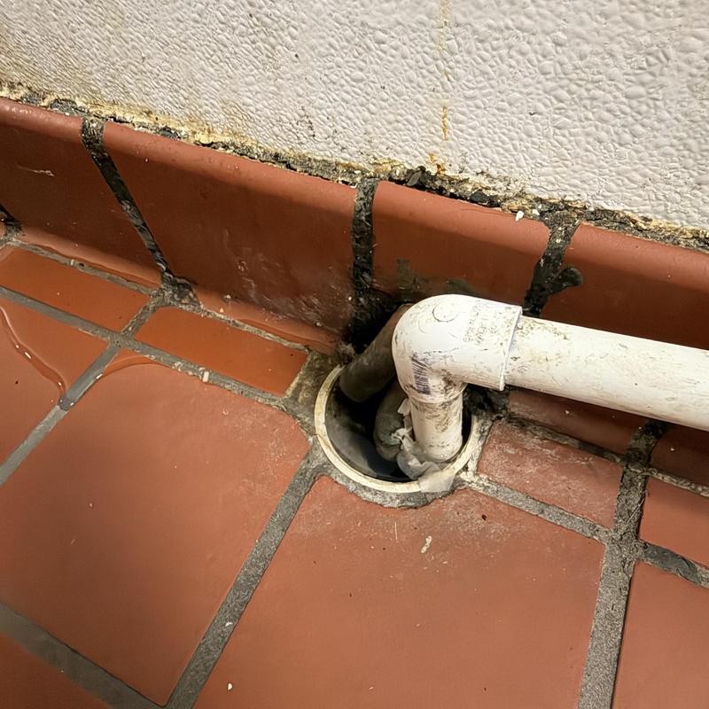 Floor drain with PVC piping and tile flooring