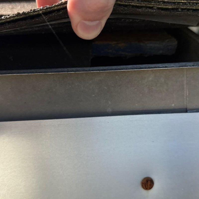 Roofing underlayment lifted to inspect flashing