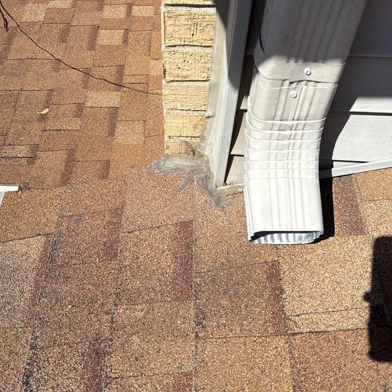 Asphalt shingles near downspout and flashing detail