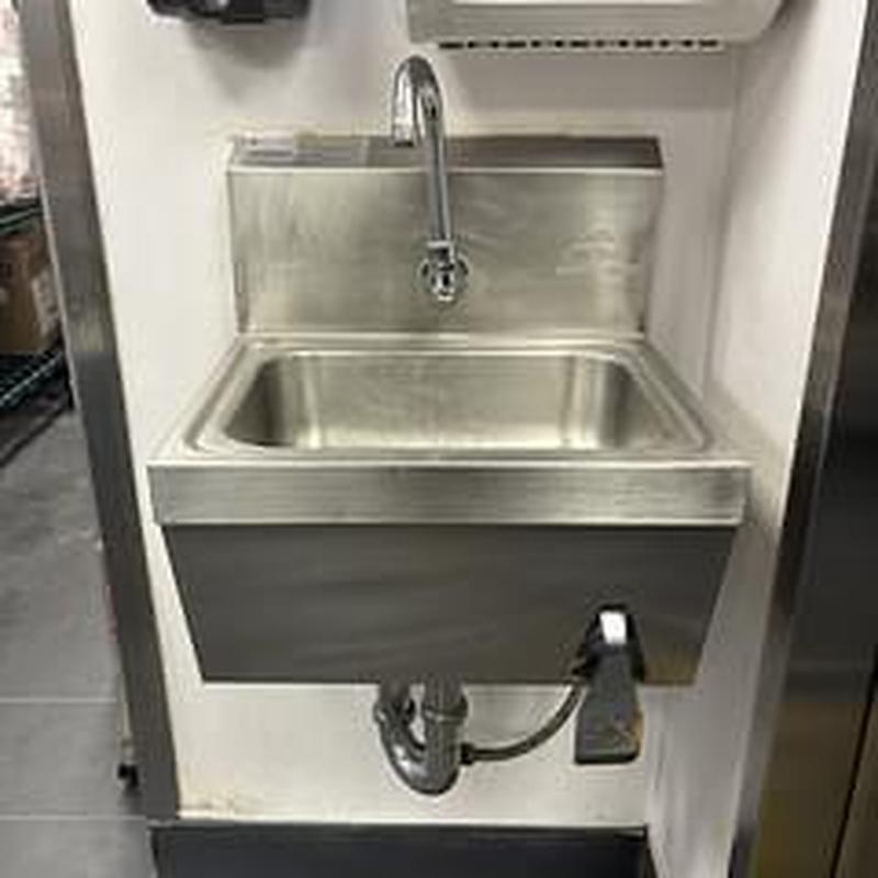 Sensor faucet and tubular drain fitting on stainless sink