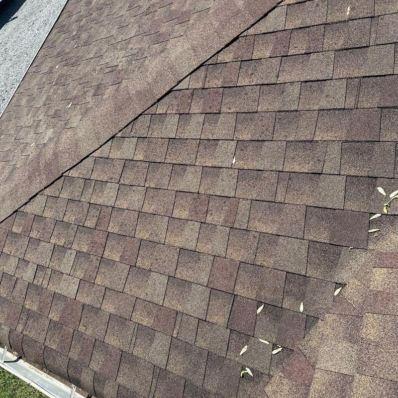 Asphalt roof shingles with hail damage and debris