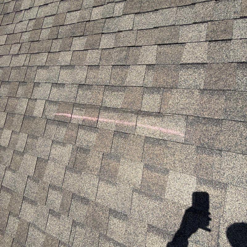 Asphalt shingle roof with chalk-marked hail damage