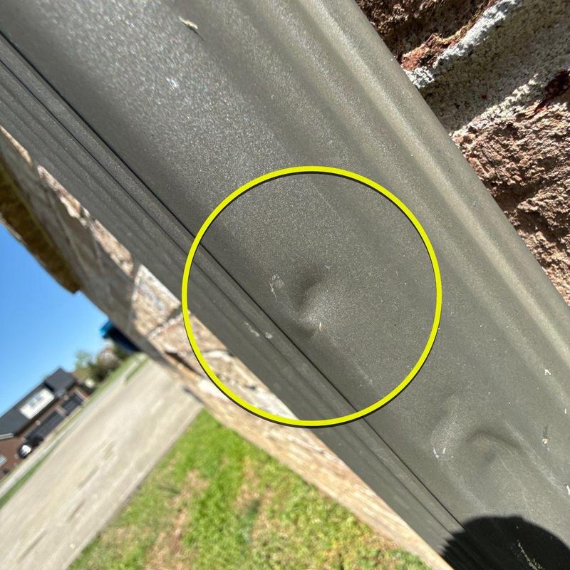 Metal gutter dent with minor surface damage