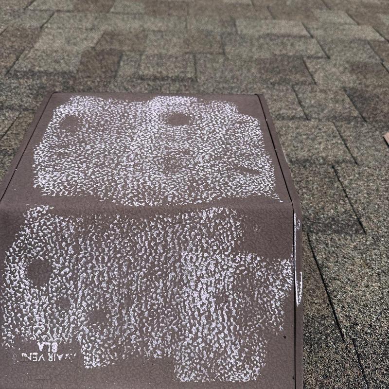 Roof ventilation cover with hail damage markings