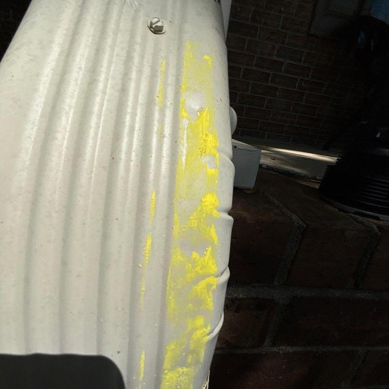 Metal downspout with yellow marking damage inspection