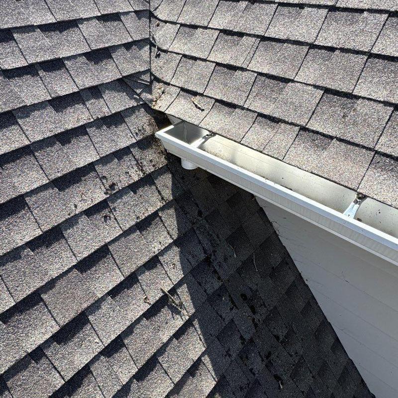 Asphalt shingle roof with hail damage near gutter system
