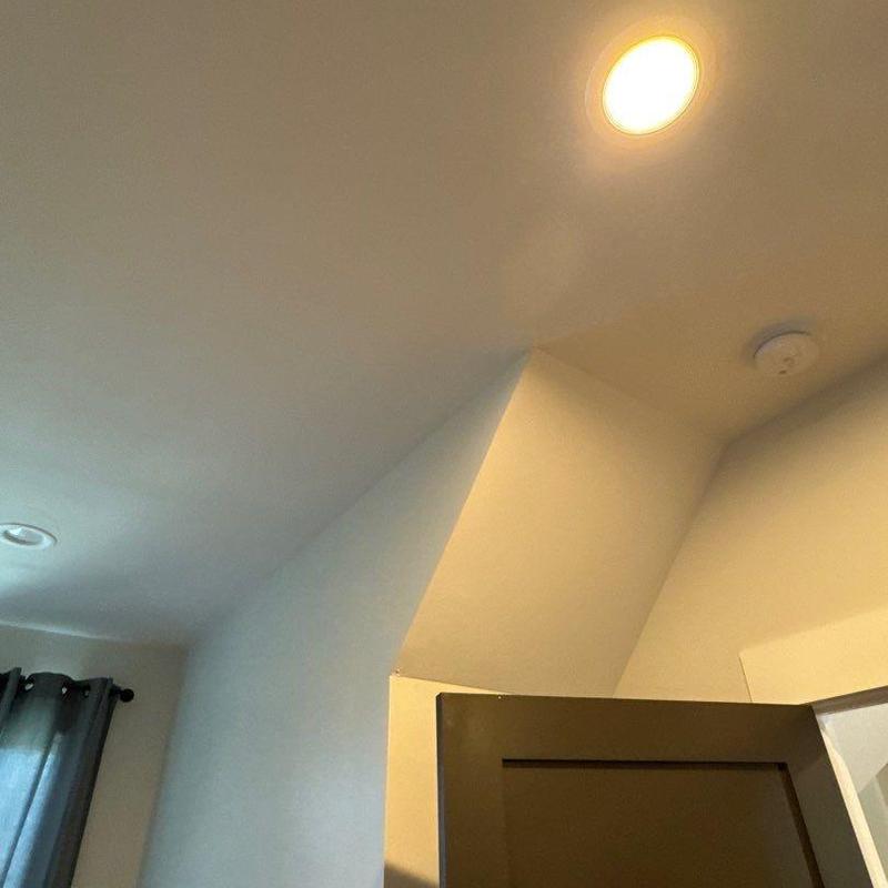Ceiling light fixture and smoke detector near ceiling corner