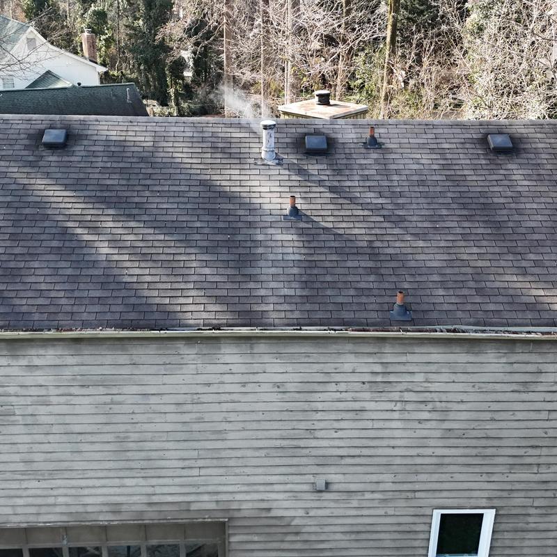 Roof with multiple vent pipes and smoke stack visible