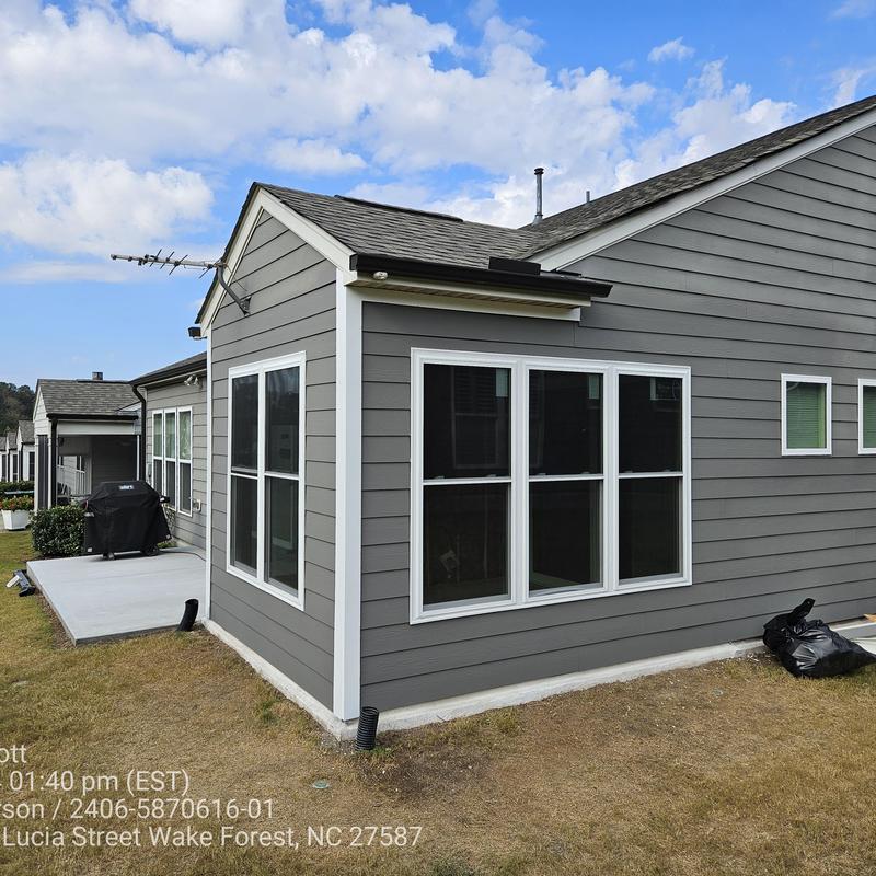 Four-season room addition with gray siding and white trim Four-season room addition with gray siding and white trim