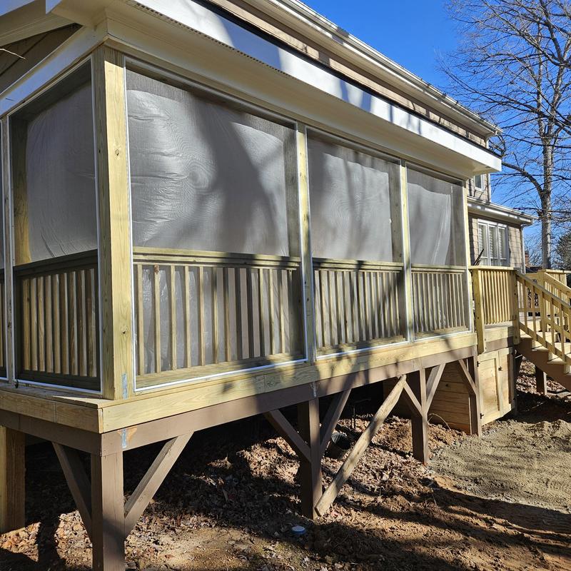 Screened porch enclosure with wooden railings and stairs Screened porch enclosure with wooden railings and stairs