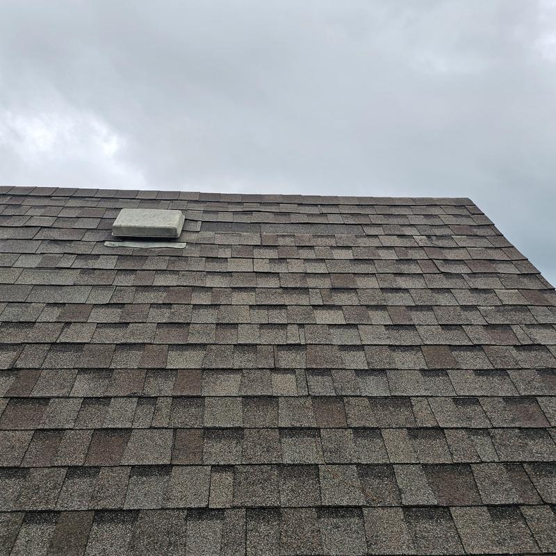 Asphalt shingle roof with hail damage near vent