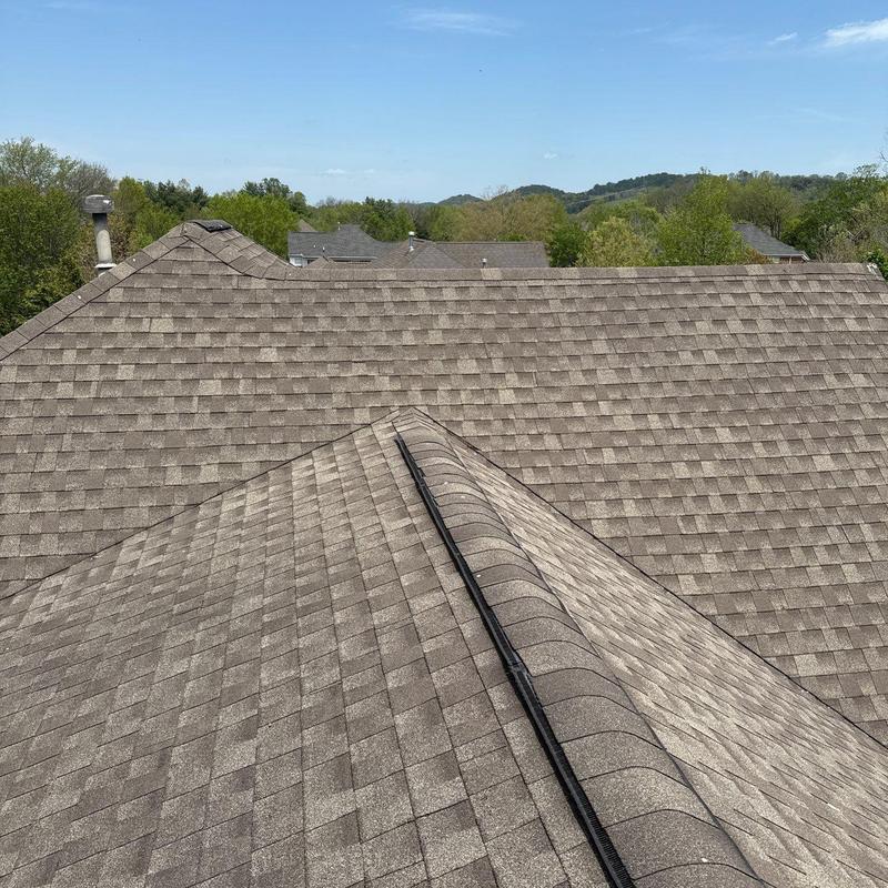 Asphalt shingle roof with ridge vent and hail damage
