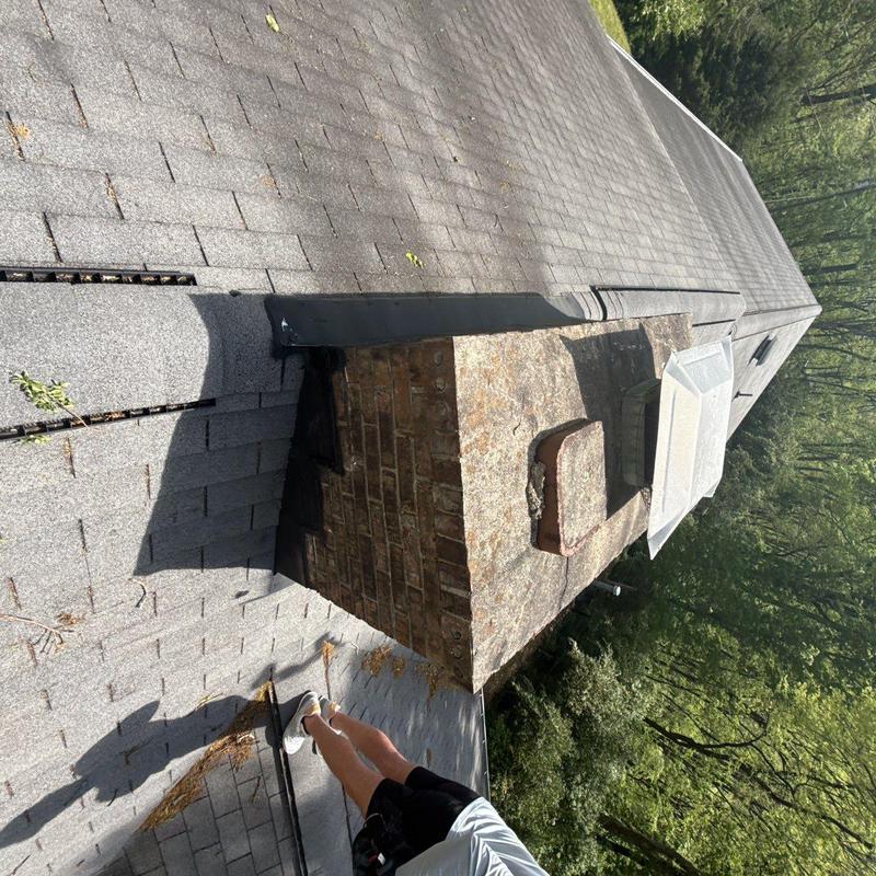 Chimney flashing on asphalt shingle roof inspection