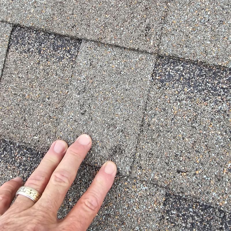 Asphalt shingles with hail and wind damage close-up
