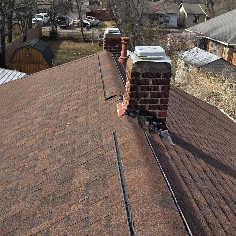 Chimney flashing with roofing shingle leaks on brown roof
