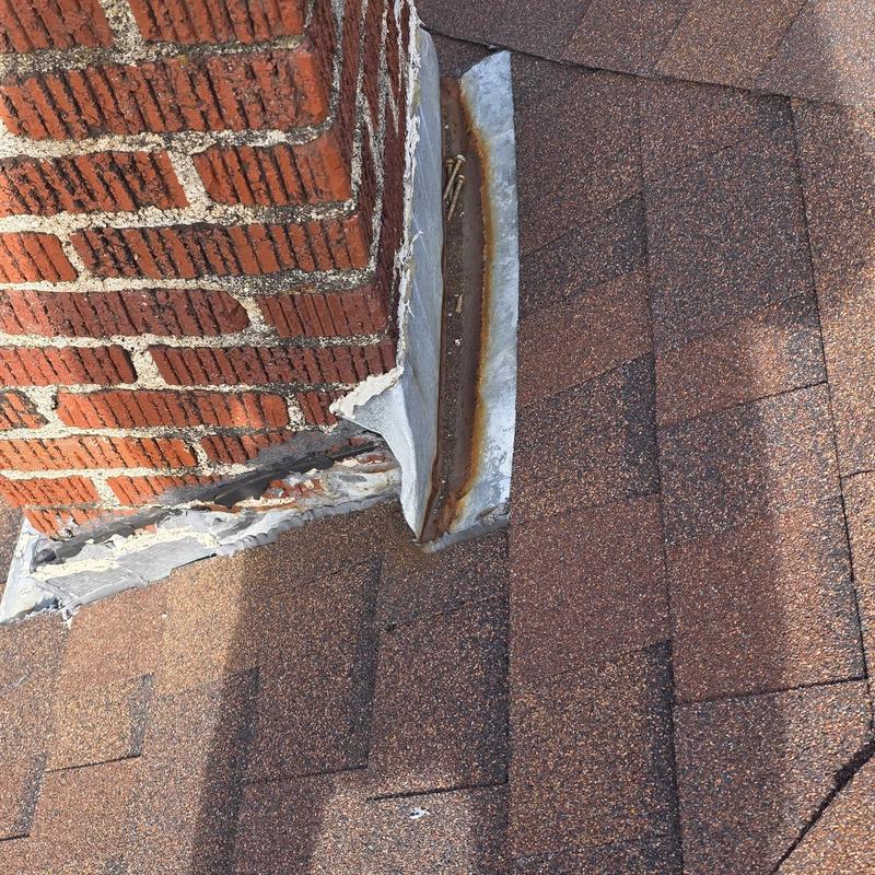 Chimney flashing with rust and deteriorated sealant on roof