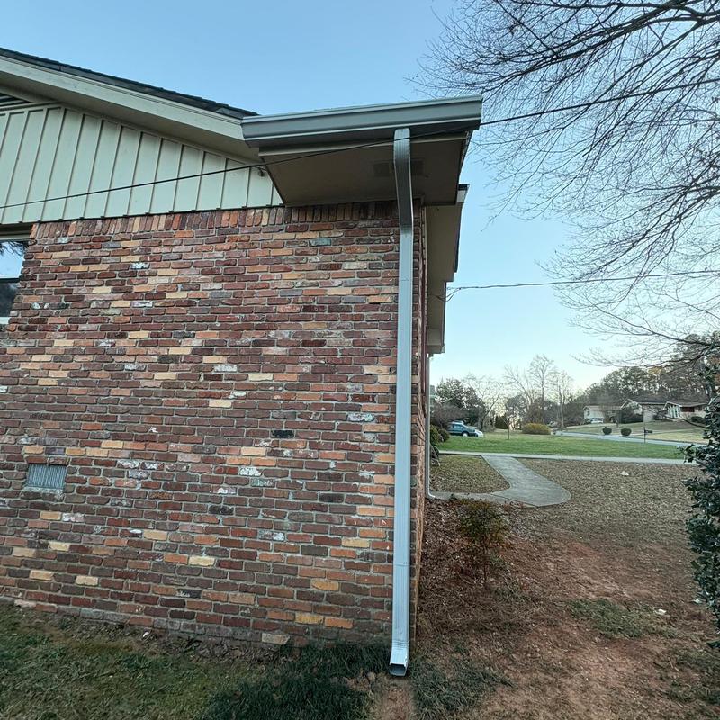 Seamless gutter and downspout on brick house corner