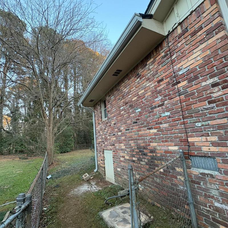 Seamless gutters and downspouts installation on brick home