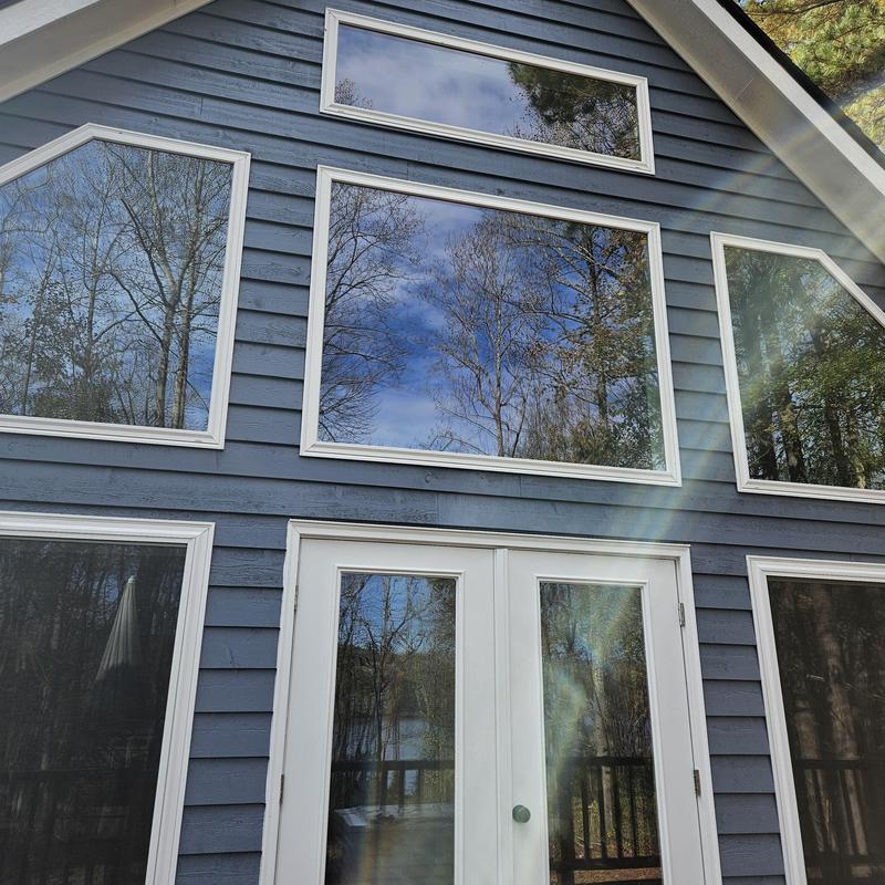 Modern window installation with white trim on lakeside home