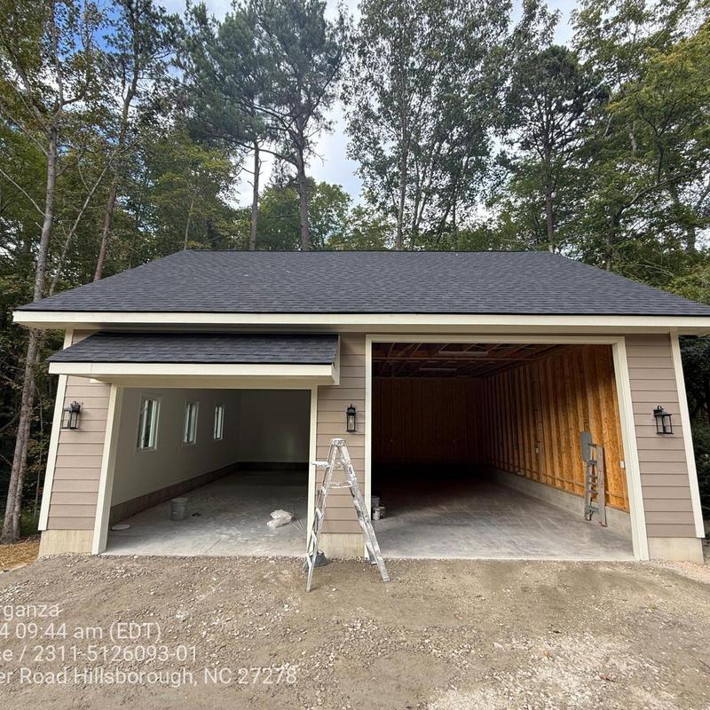 Standalone garage exterior with dual bays under construction Standalone garage exterior with dual bays under construction