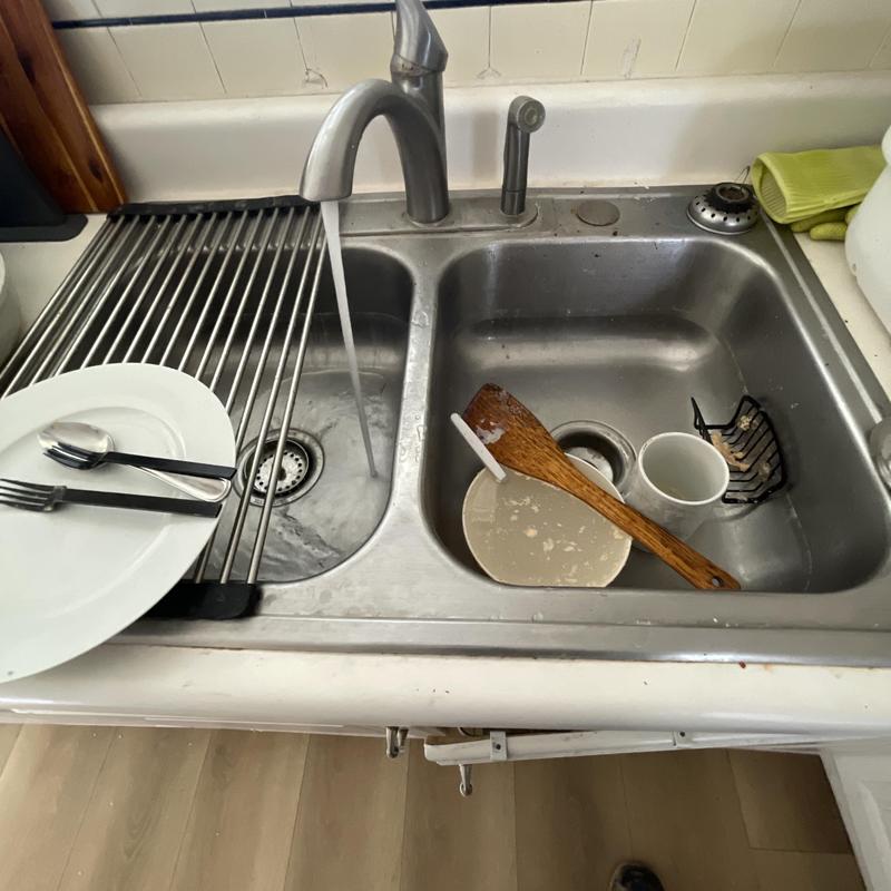 Kitchen sink drain with dishes and running water