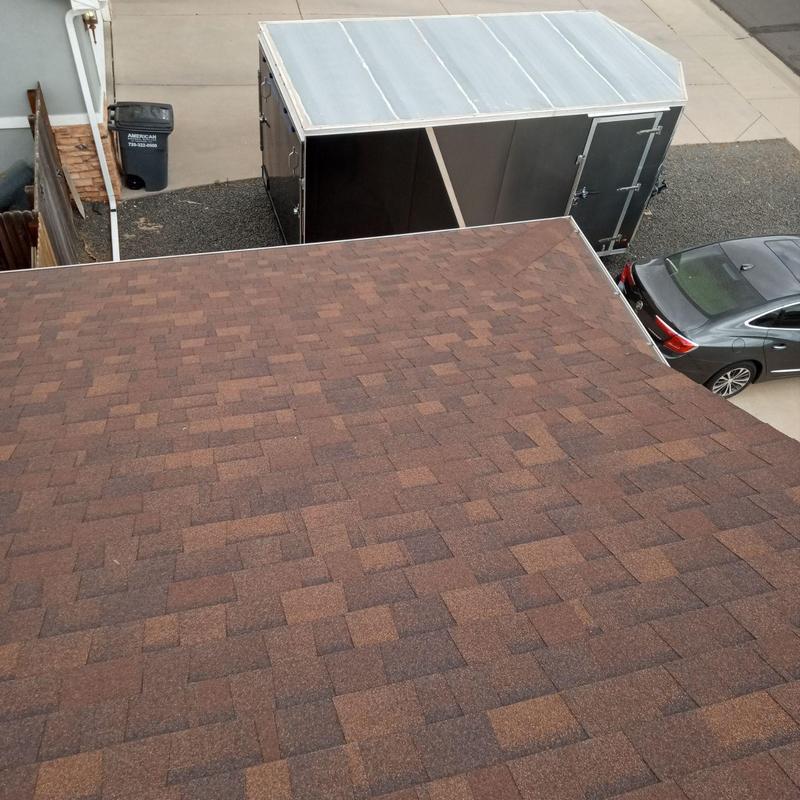 Asphalt shingle roof surface with surrounding driveway and trailer Asphalt shingle roof surface with surrounding driveway and trailer