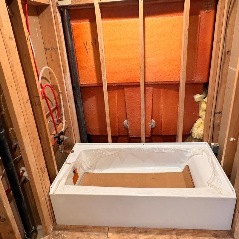 Bathtub installation with plumbing rough-in and insulation