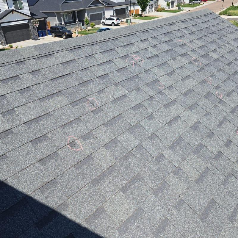 Shingle roof with hail damage marked for inspection Shingle roof with hail damage marked for inspection