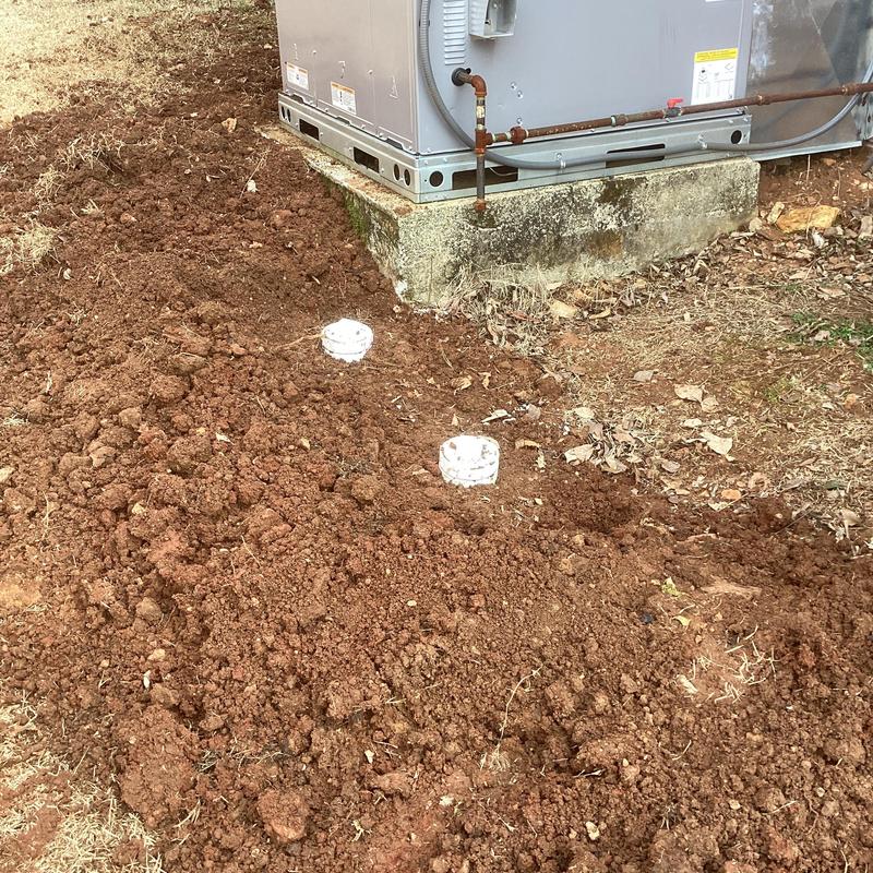 New sewer drain trench beside AC unit and concrete pad