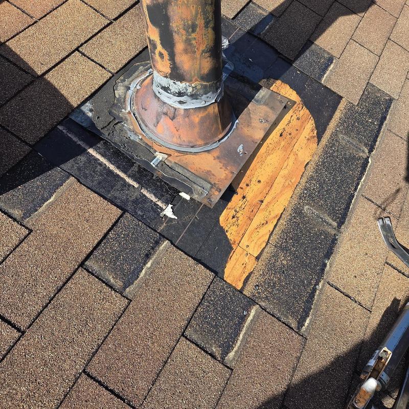 Vent pipe flashing with new shingles on roof