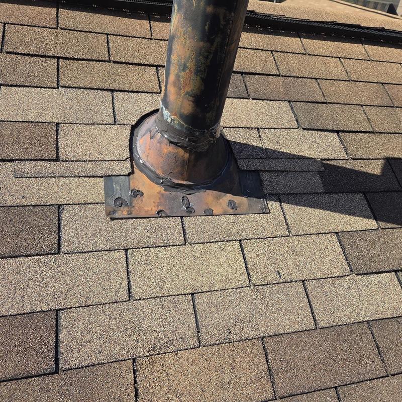 Vent pipe flashing on shingle roof with rust and caulking