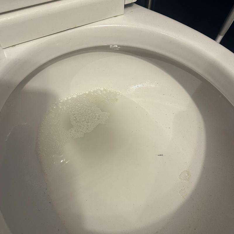 Toilet bowl with water and foam buildup