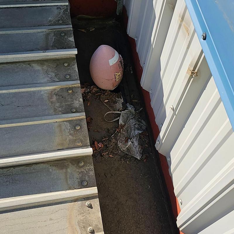 Metal roof with debris and a football present Metal roof with debris and a football present